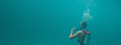 A scuba divers diving naked, exploring the depth of the ocean.